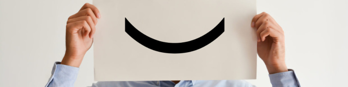 Wertschöpfungskette Mann in blauem Hemd hält Papier mit Smiley vor Gesicht