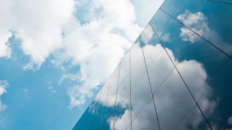 Cloudtechnologie Wolken spiegeln sich in Glasgebäude 
