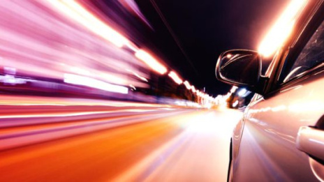 Autonomes Fahren silbernes Auto fährt nachts durch Stadt mit Lichtern