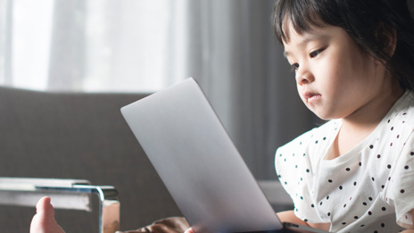 Künstliche Intelligenz Kind sitzt und schaut auf Laptop