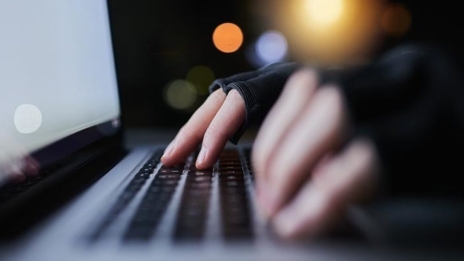 Krypto-Assets Hände tippen auf Laptop-Tastatur im Dunkeln