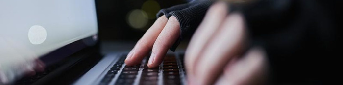 Krypto-Assets Hände tippen auf Laptop-Tastatur im Dunkeln