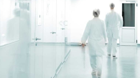 Arbeitswelt 4.0 Gesundheitswesen Frauen in Ärztekitteln laufen weißen Flur entlang