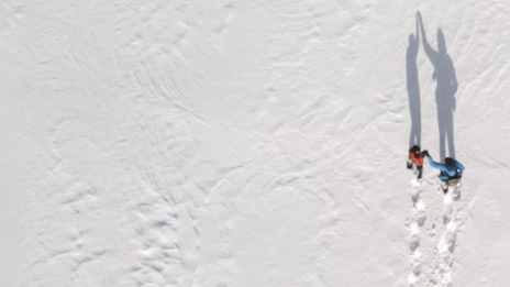 Personen laufen durch Schnee Vogelperspektive