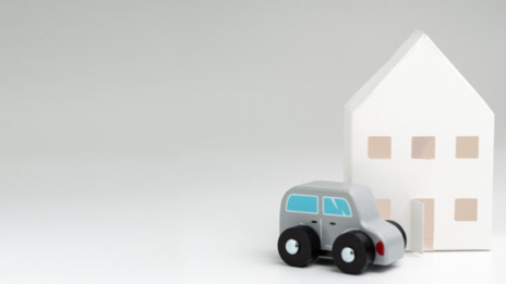 Firmenwagen: Spielzeugauto vor Spielzeughaus