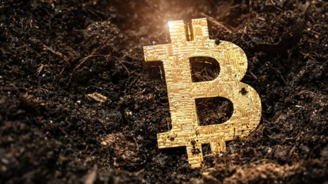 Goldenes B für Bitcoin auf schwarzer Erde