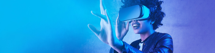 Digitale Transformation: Eine Frau bewegt sich mithilfe einer VR-Brille durch eine virtuelle Welt.