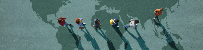 Decoupling: Eine Gruppe von Menschen, von oben fotografiert, bewegt sich über eine auf den Boden gemalte Weltkarte.
