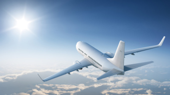 Flugzeug fliegt über den Wolken der Sonne entgegen. 
