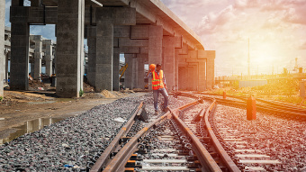 Porträt eines Architekten, der den Layoutplan der Räume studiert, seriöser Bauingenieur, der mit Dokumenten auf der Baustelle arbeitet.