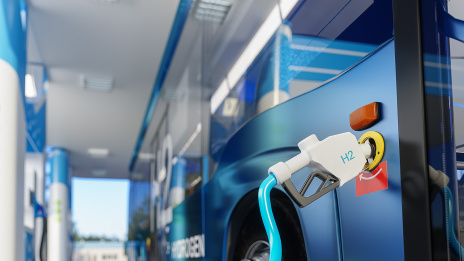 ESG: Ein Omnibus steht an einer Tankstelle. An der Fahrzeugseite ist eine Zapfpistole für Wasserstoff in den Tank eingeführt. 