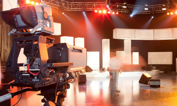 Compliance: Ein leeres Fernsehstudio, im Vordergrund links eine TV-Kamera