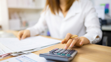 Automatisierte Steuererklärung: Eine Unternehmerin sitzt am Schreibtisch und macht eine Steuererklärung.
