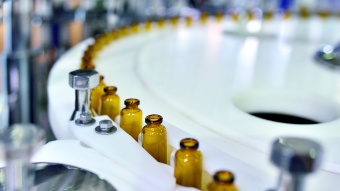 Lieferketten in der Pharmaindustrie: In einer Industriehalle werden Flaschen mit Arzneimitteln befüllt.