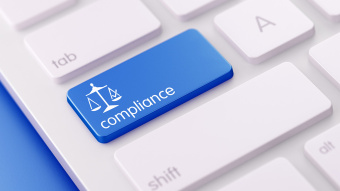 DAC7: Auf einer Tastatur eines Mitarbeitenden im Unternehmen sieht man den Begriff "Compliance".