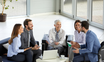 Eine Gruppe von Mitarbeitenden eines Familienunternehmens bespricht in einem Meeting im Büro neue Geschäftsideen.