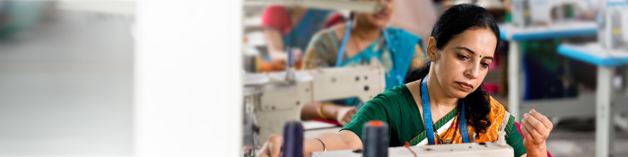 Frau arbeitet an einer Nähmaschine in einer Textilfabrik