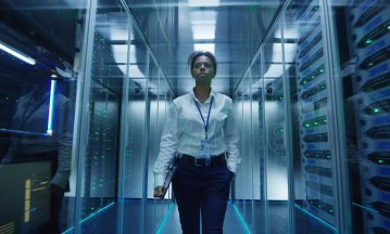 Cybergefahren für Unternehmen: Eine Frau läuft durch einen Serverraum.