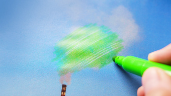 EmpCo und Green Claims Directive: Eine Person malt Rauch aus Industrieschornstein, der auf einem Foto dargestellt wird, grün an.