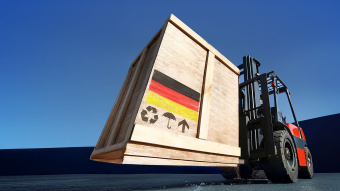 Aufnahme eines Hubwagens, der eine Holzkiste mit Deutschland-Fahne transportiert. 