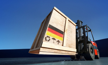 Aufnahme eines Hubwagens, der eine Holzkiste mit Deutschland-Fahne transportiert. 