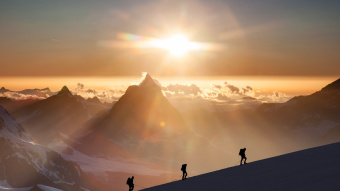 Menschenkette auf Bergrücken bei Schnee