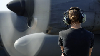 Eine Soldatin inspiziert ein kürzlich repariertes Flugzeug des Typs Lockheed C-130.