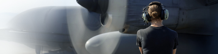 Eine Soldatin inspiziert ein kürzlich repariertes Flugzeug des Typs Lockheed C-130.