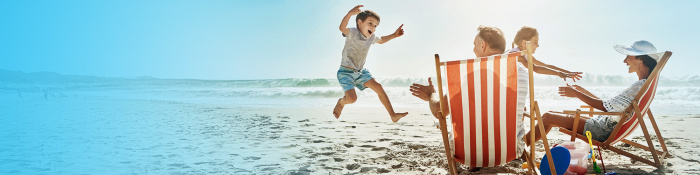 Strandbild mit rot-weiß gestreiftem Sonnenstuhl, Familie mit zwei Kindern, kleiner Junge springt, Eltern sitzen auf Strandstühlen