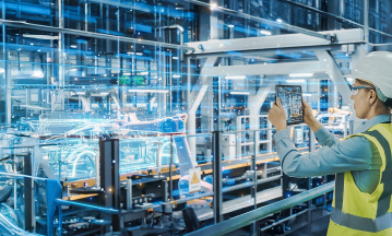 Person mit Tablet vor digitaler Abbildung einer Produktionsstraße 