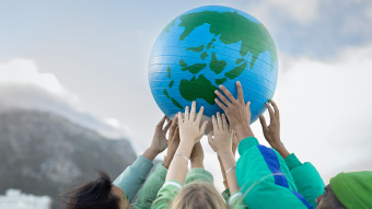 Hände, die einen Weltkugel in die Höhe halten 