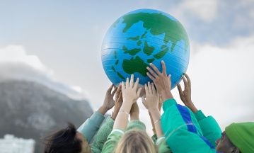 Hände, die einen Weltkugel in die Höhe halten 