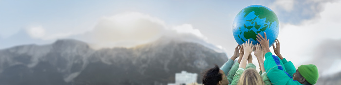 Hände, die einen Weltkugel in die Höhe halten 