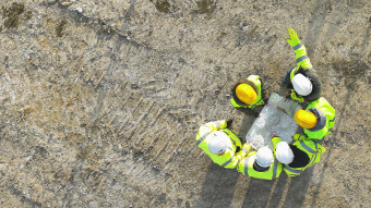 Bauarbeiter auf einer Baustelle von oben aufgenommen. 