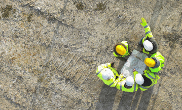 Bauarbeiter auf einer Baustelle von oben aufgenommen. 