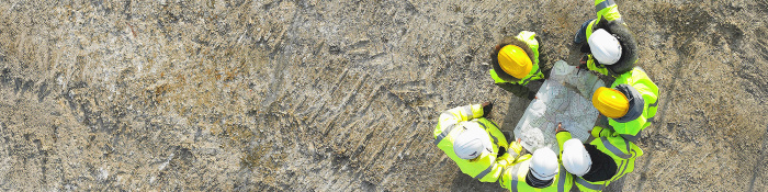 Bauarbeiter auf einer Baustelle von oben aufgenommen. 