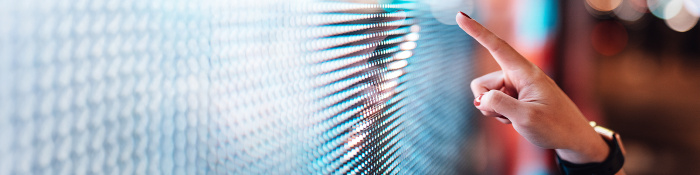 Eine Frauenhand zeigt mit dem Finger über eine digitale Oberfläche.