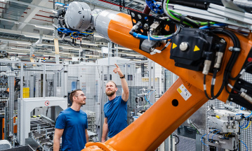 Industrieroboter in moderner Fertigungsumgebung mit Fokus auf Ressourceneffizienz und Wiederverwendung von Komponenten in der Kreislaufwirtschaft.