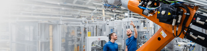 Industrieroboter in moderner Fertigungsumgebung mit Fokus auf Ressourceneffizienz und Wiederverwendung von Komponenten in der Kreislaufwirtschaft.