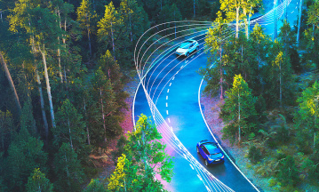 Autos von oben fotografiert fahren durch einen Wald. Zu sehen sind außerdem dynamische Fahrlinien.