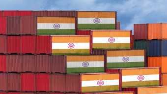 Das Bild zeigt aufeinander gestapelte Container. Die Container in der ersten und obersten Reihe sind mit einer Indien-Fahne bedruckt
