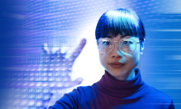 Eine Frau mit Brille tippt mit ihren Fingern auf ein digitales Dashboard.