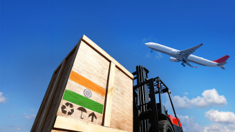 International Business und Welthandel: Ein Frachtflugzeug hebt vom Flughafen ab, im Vordergrund sieht man Container und einen Gabelstapler - Freihandelsabkommen EU/Indien