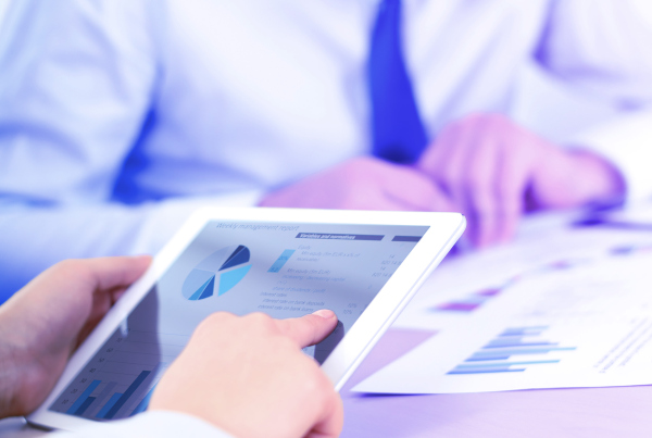 Business Kollegen analysieren Diagramme auf einem Tablet, Akturielles Monitoring: Geschäftssteuerung mit technischen Preisen