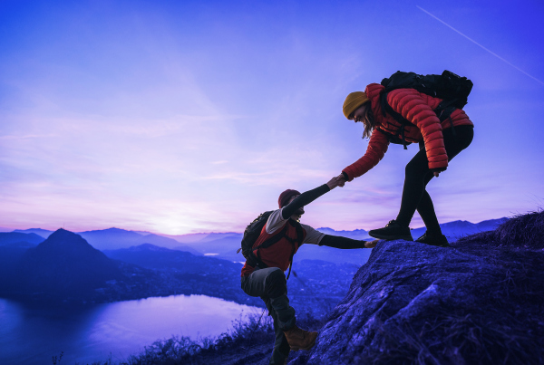 Zwei Kletterer erklimmen einen Gipfel, im Hintergrund Bergpanorama, Mehr als Trainings: Cloud Enablement braucht neue Lern- und Dialogformate