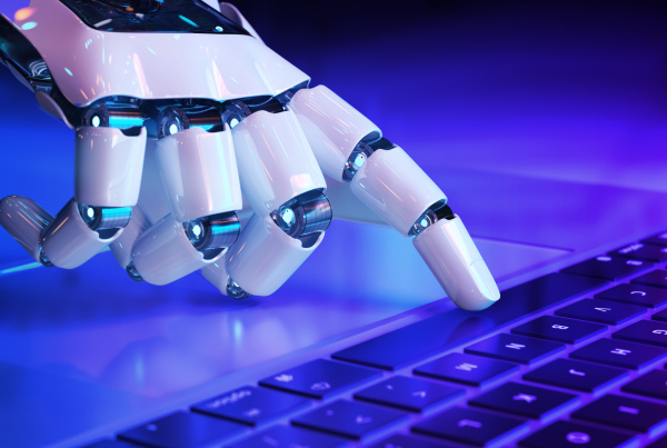 Roboterhand, die auf einer Computertastatur tippt. Symbolbild für Mehr Nähe durch Technik: Künstliche Intelligenz an der Kundenschnittstelle