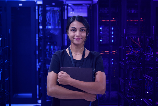 Junge Frau steht vor Serverraum, Symbolbild für RiskTechs: Innovative Technologien für die Risiko-IT