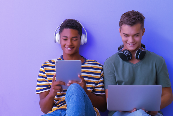 Zwei Teenager schauen auf Laptop und Tablet