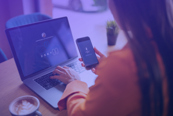 Frau verifiziert Login mit Handy und Laptop