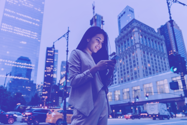 Frau am Handy, Großstadt, KI, Häuser, mobil, Customer Experience